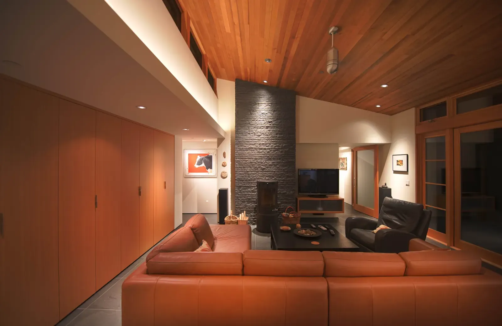 Living room under a cedar ceiling, stone chimney beyond