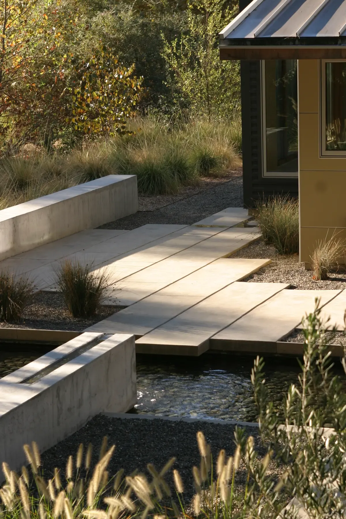 Concrete steps and water channel running alongside the house