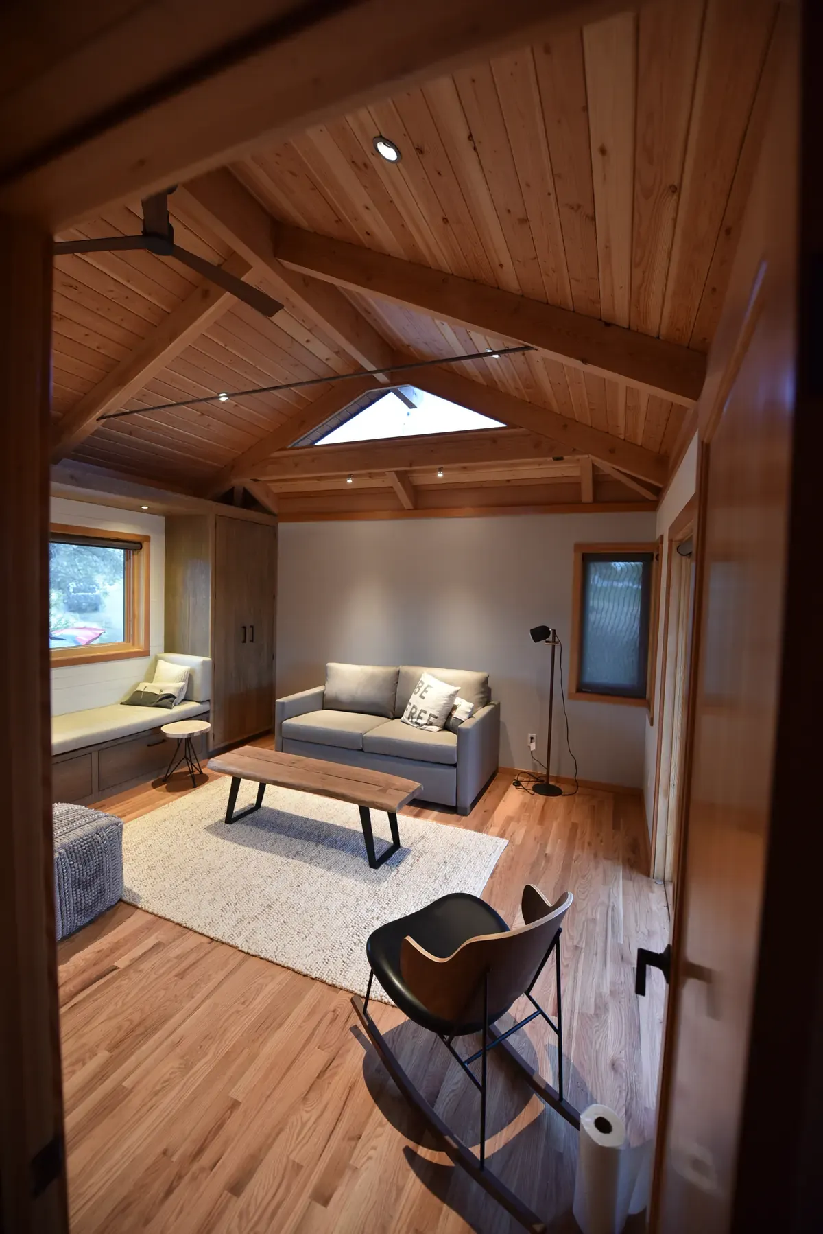 Living space with a skylight in the timber ceiling, sofa facing the view