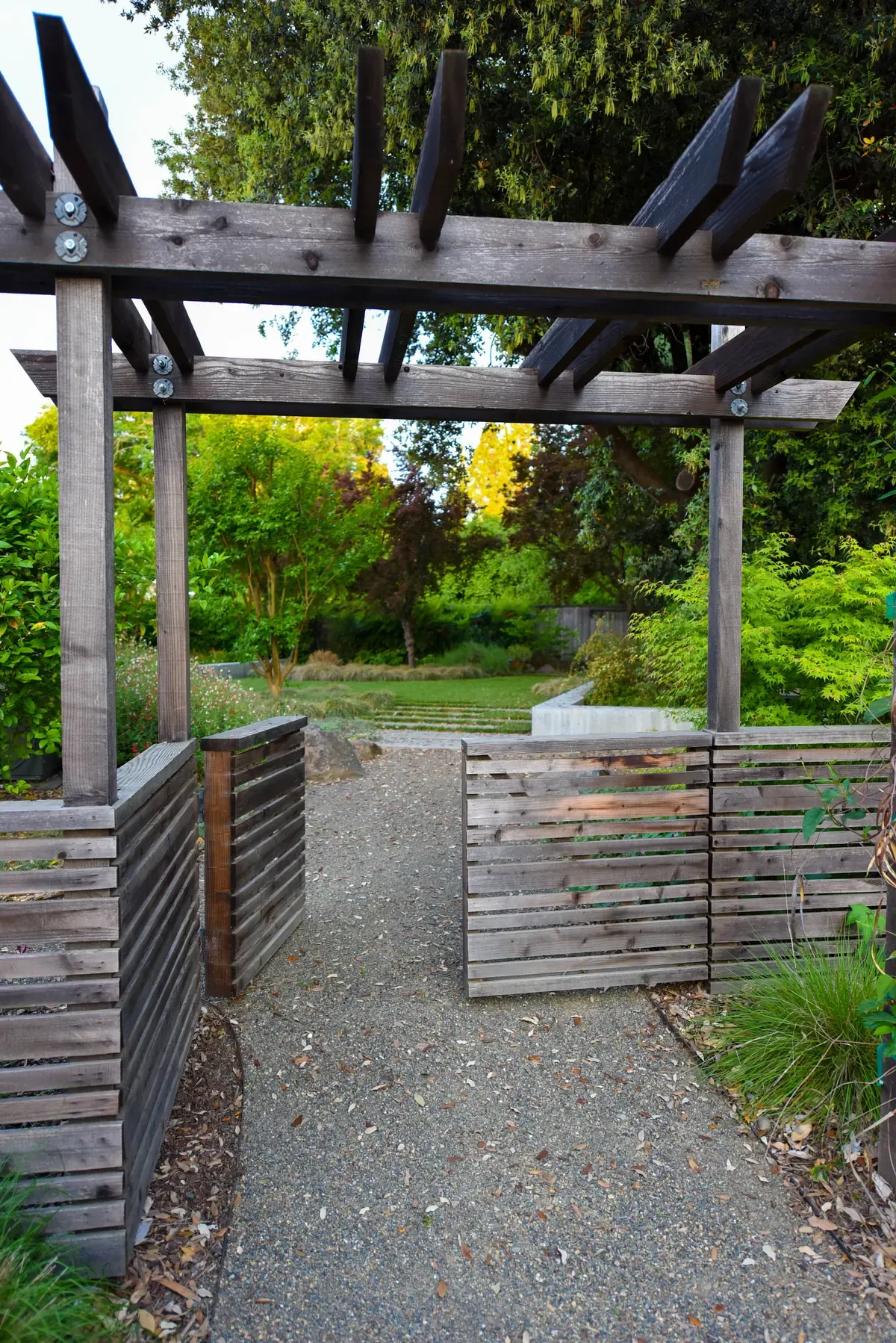 Timber pergola and gate above the gravel path
