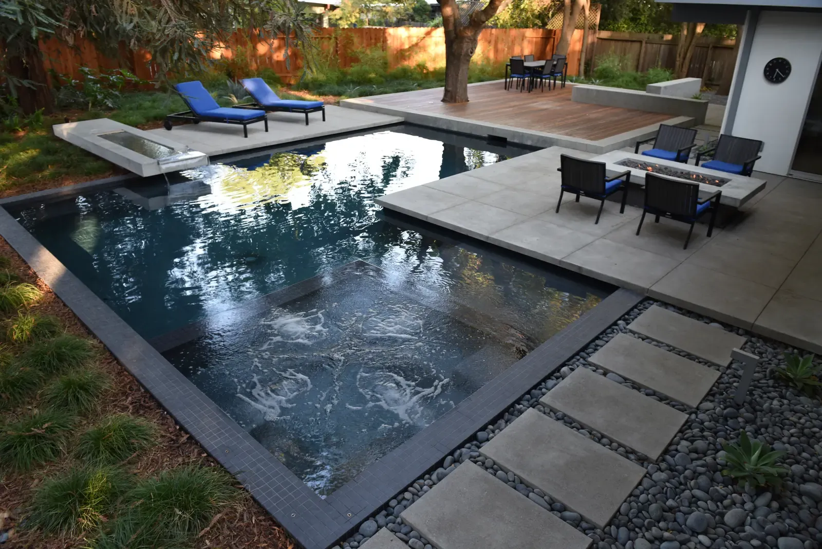 Pool and seating seen across stepping stones set into gravel