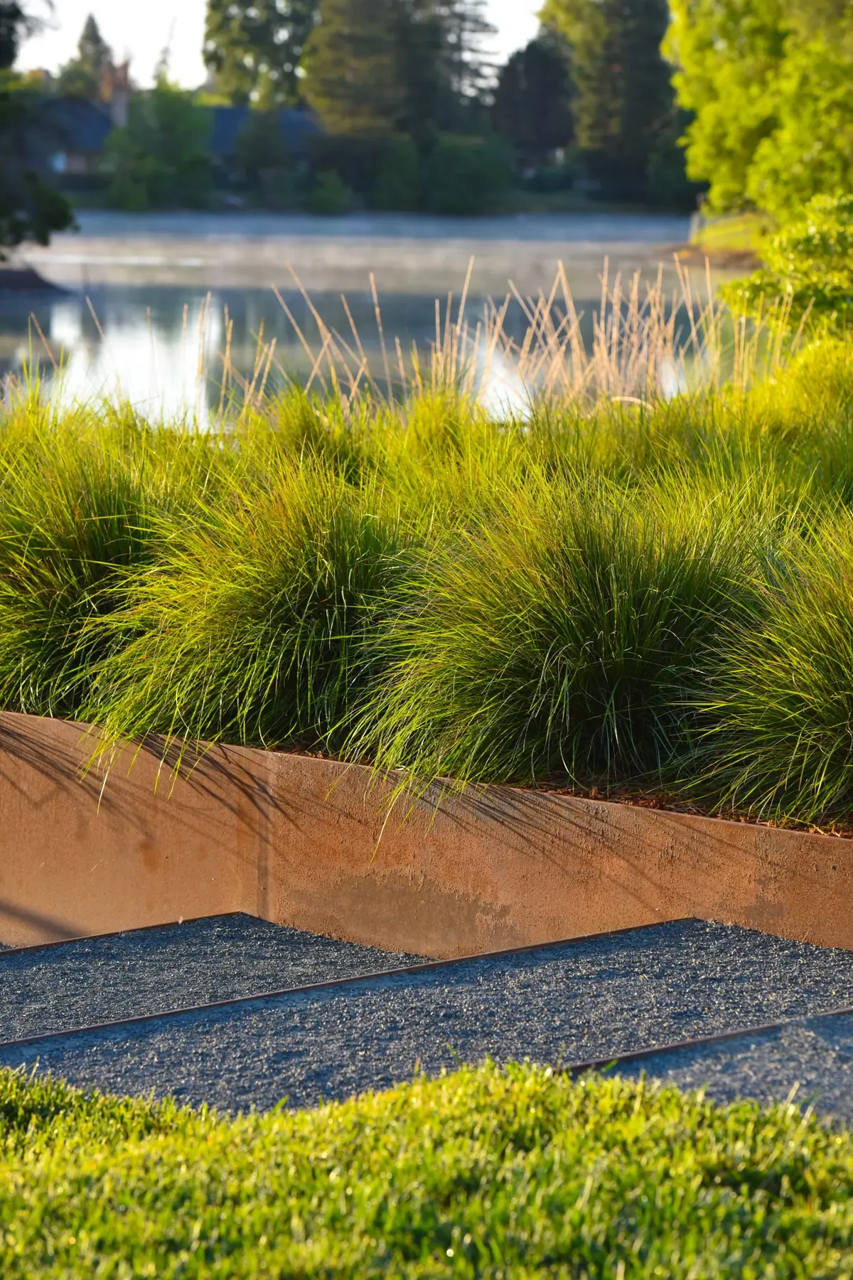 Grasses along a weathering-steel edge with the lake beyond