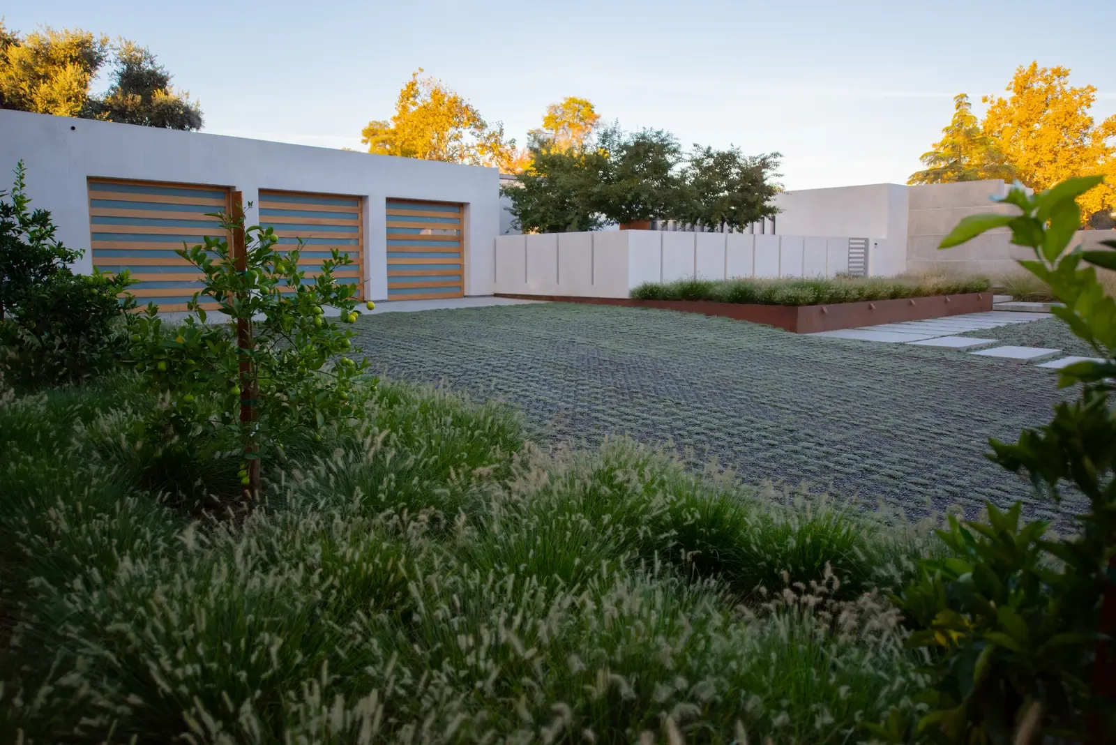 Cobbled motor court enclosed by white walls and planting