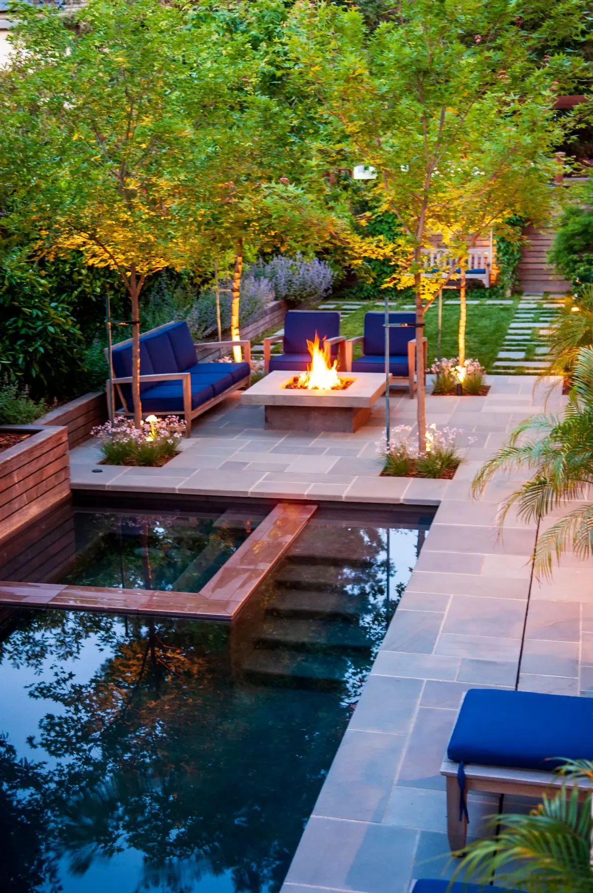 Fire table beside the pool at dusk, seating around it